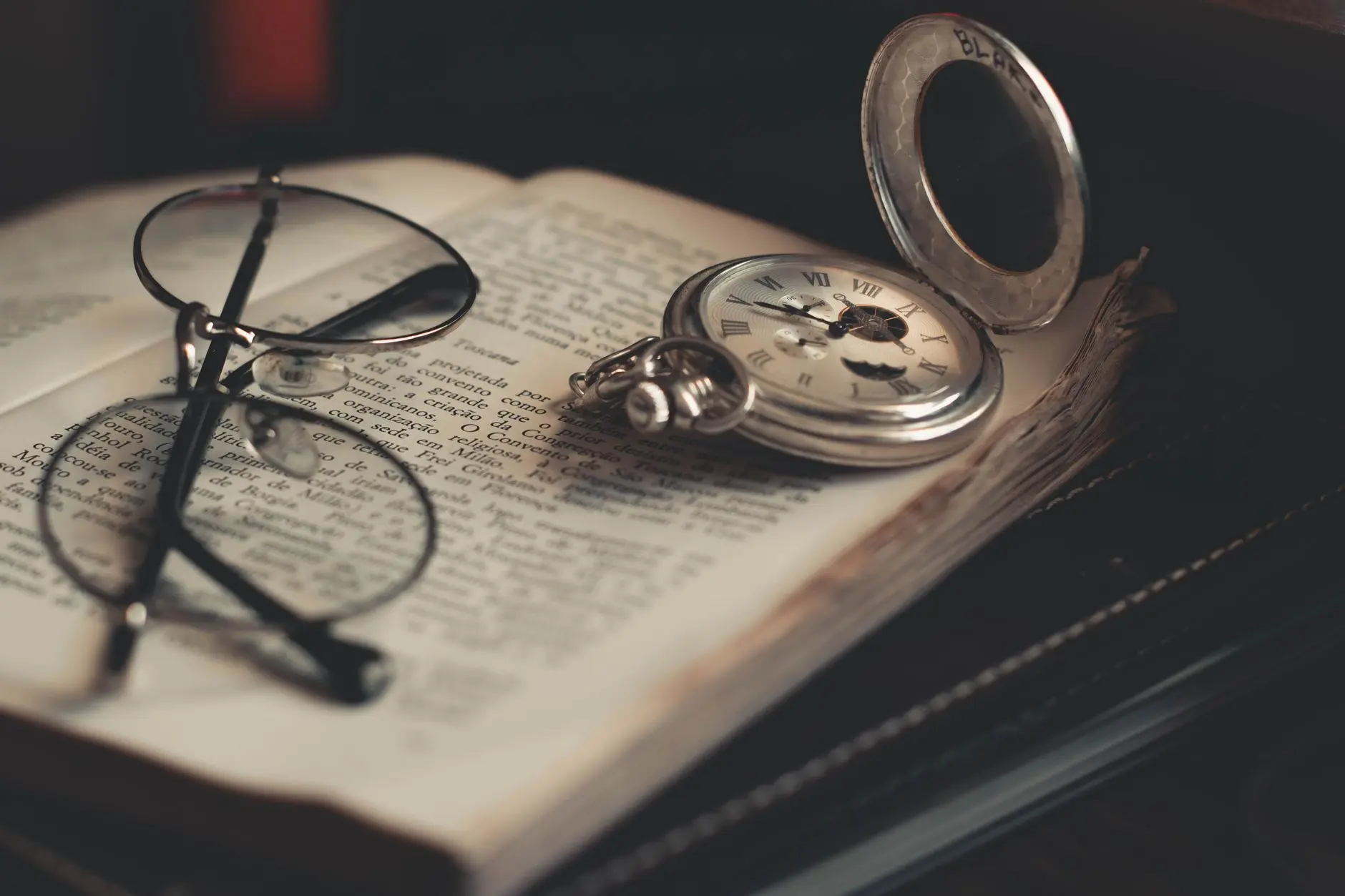 A brass compass lies on a wooden surface, illuminated by natural light.
