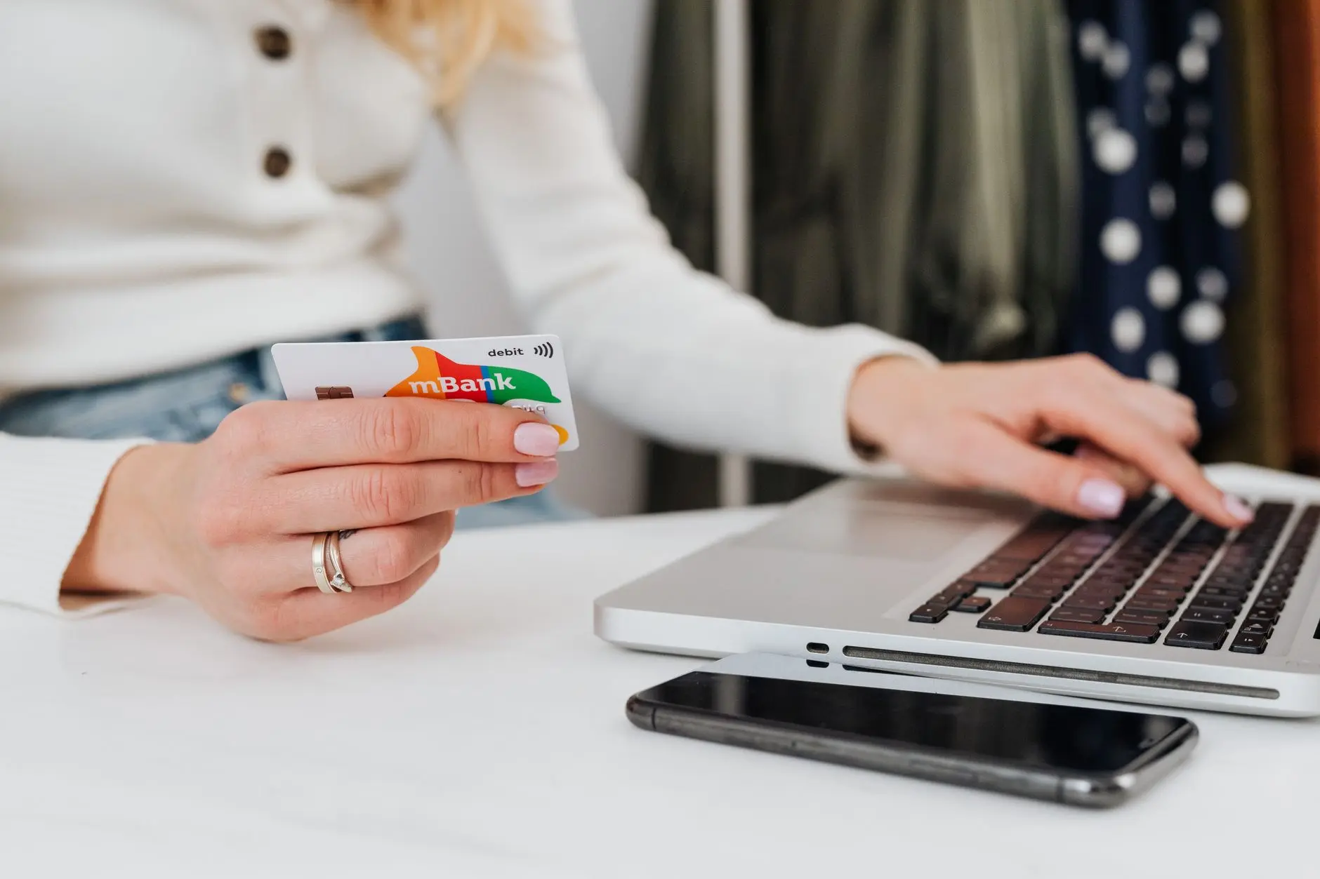 Laptop sa e-commerce platformom Srbija, kutije za dostavu i platne kartice na stolu